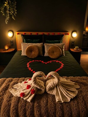A bed with a heart-shaped decoration made of red roses and a towel arrangement. - Mana Suite & Spa - Luxury & Wellness (Tarare)