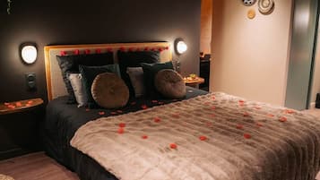 A bedroom with a bed, bedside tables, and decorative wall art.