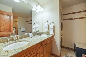 Un baño con dos lavamanos, un espejo grande y un mueble de tocador de madera.