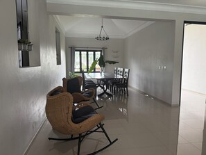 Un salón amplio con una mesa de comedor, sillas y un ventanal grande.