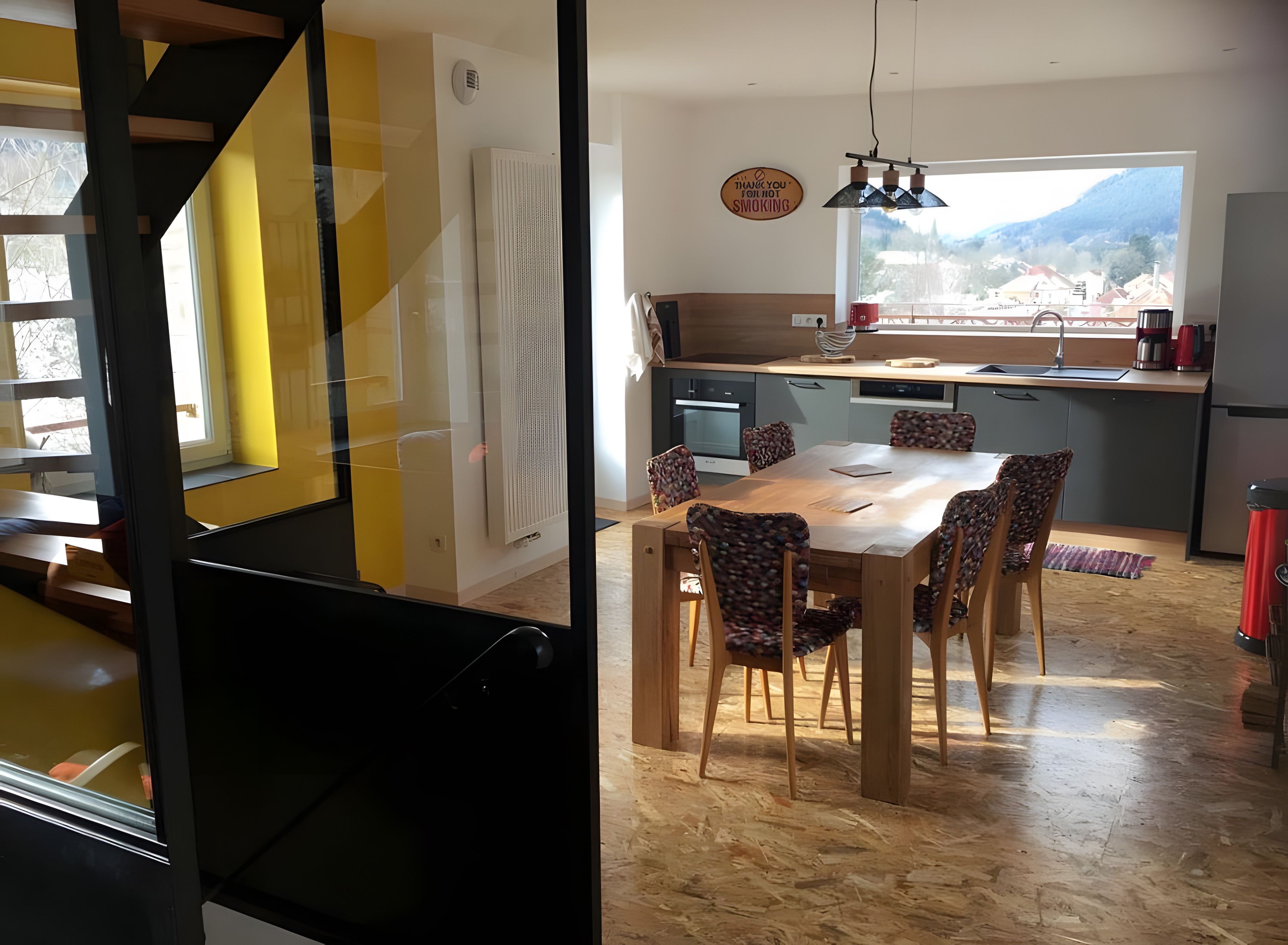 Une cuisine moderne avec un coin repas, une vue sur la ville et un panneau indiquant qu'il est interdit de fumer.