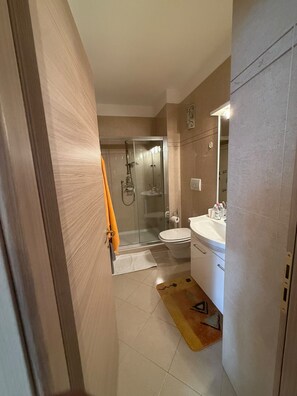Ein Badezimmer mit Dusche, Toilette und Waschbecken.