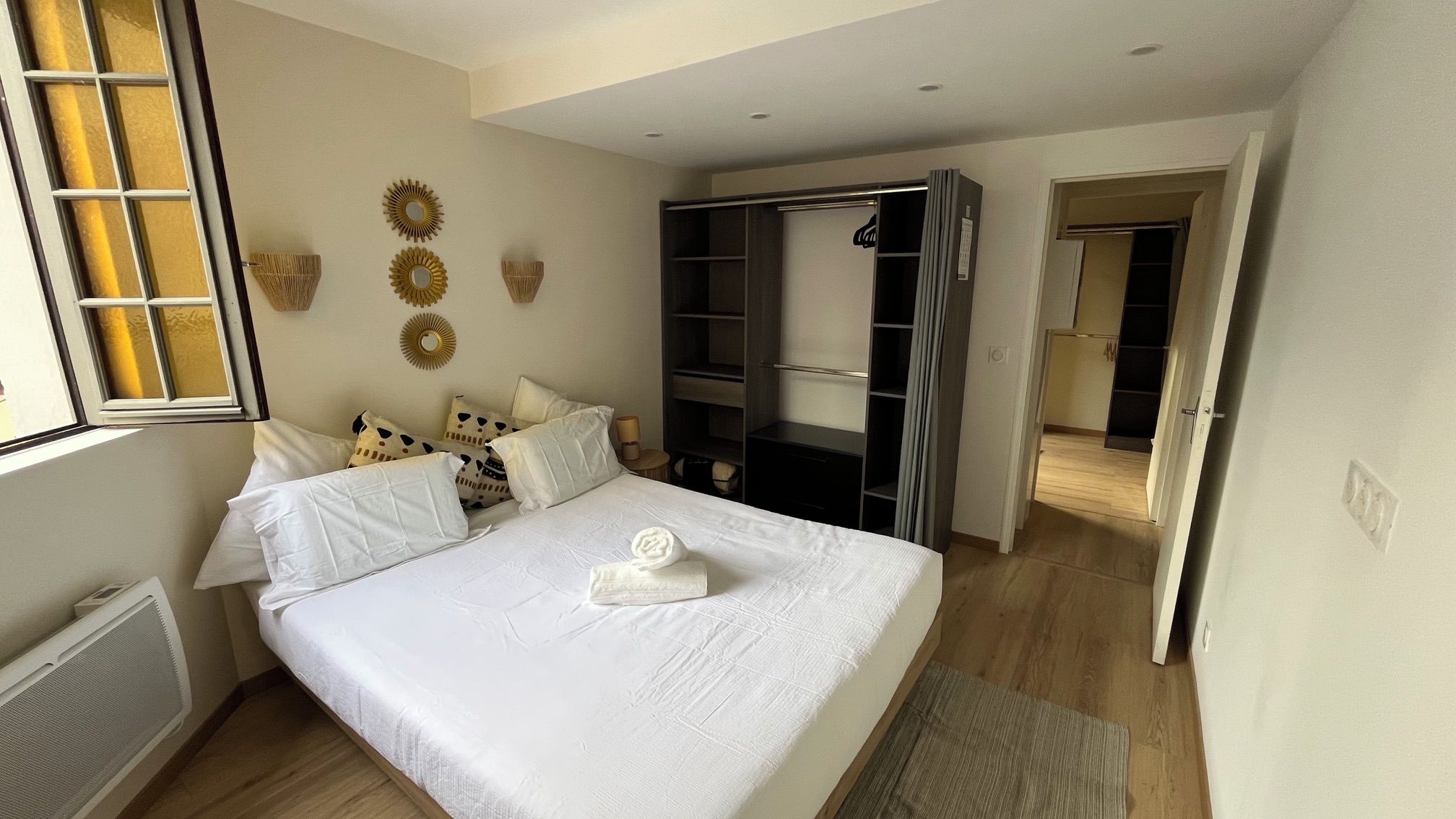 A bedroom with a bed, a wardrobe, and a window.