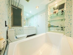 Un baño moderno con bañera, inodoro y lavamanos.