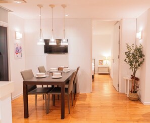 Un comedor moderno con una mesa de madera, sillas e iluminación colgante.