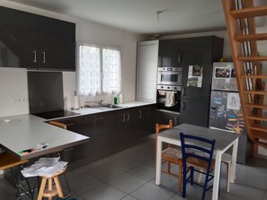 Une cuisine équipée d’une table à manger, de chaises et d’un réfrigérateur.