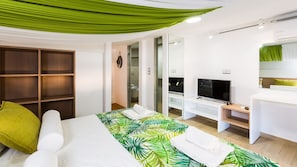 Une chambre d’hôtel moderne équipée d’un lit, d’une télévision, d’un bureau et d’une armoire.