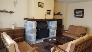 Una sala de estar con chimenea de piedra, muebles de madera y adornos en la pared.