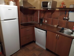 Una cocina compacta equipada con refrigerador, microondas, pileta y lavavajillas.
