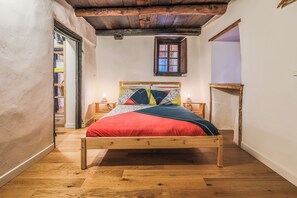 A bedroom with a wooden bed, a window, and a wooden floor. - La Casetta ai piedi del Monte Rosa (Piemonte)