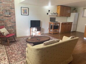 Un salon avec un canapé, une table basse, un téléviseur et une cheminée.