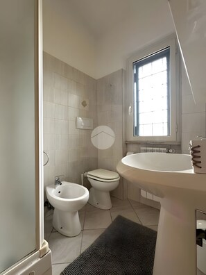 Un bagno con il water, bidet e lavandino.