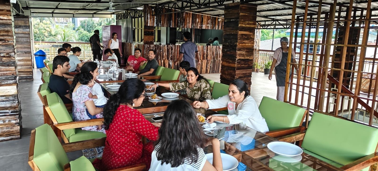 A restaurant with outdoor seating, wooden furniture, and a view of the surrounding area.