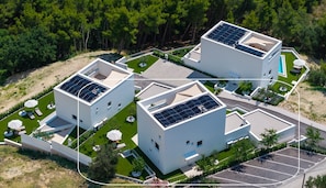 Aerial view of the villas in their green hillside setting, showing the private gardens, rooftop solar panels, spacious grounds and surrounding forest. - Villa A, modern villa on a peaceful hillside in Podstrana (Podstrana)