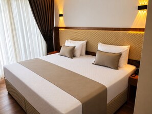 Un lit double avec une tête de lit matelassée, deux tables de chevet et une lampe de chevet.