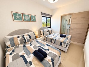 Een hotelkamer met twee bedden, een badkamer en uitzicht op de omgeving.