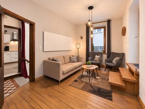 Ein modernes Wohnzimmer mit einer Couch, Sesseln, einem Couchtisch und einer Holzbank.