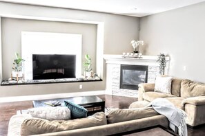 Una sala de estar con chimenea, un sofá y una televisión.