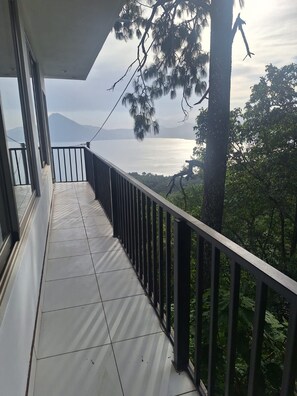 Un balcón con vistas al agua y montañas.