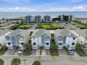 Un quartier résidentiel composé d’immeubles à plusieurs étages, d’un parking et offrant une vue sur la mer.