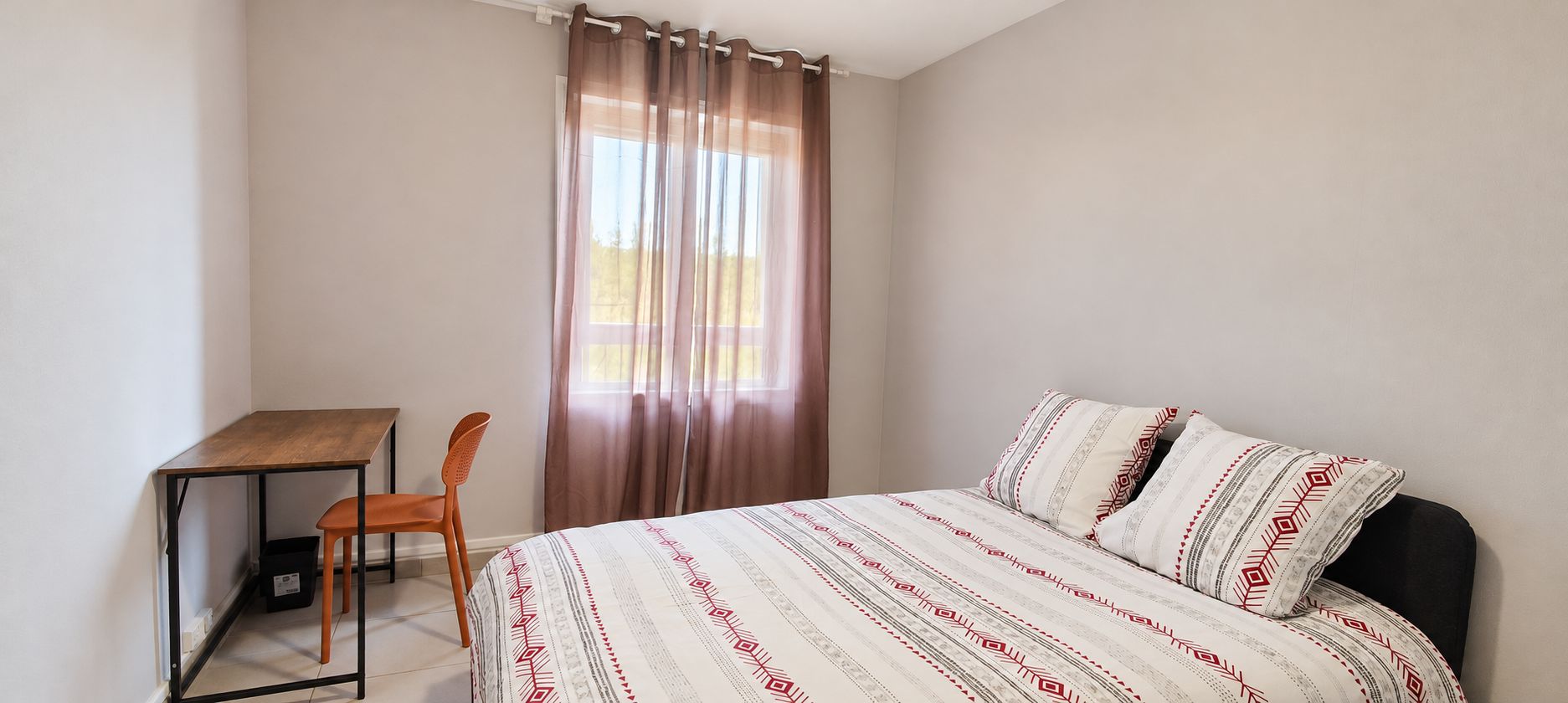 Ein Schlafzimmer mit einem Bett, einem Schreibtisch und einem Stuhl.