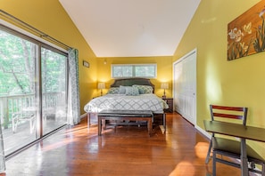Un dormitorio con una cama grande, un banco, una mesa y vistas al exterior.