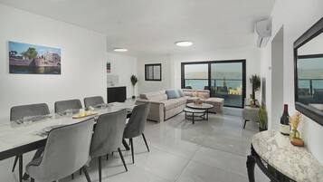 Een moderne woonkamer met een eethoek, een zithoek en een groot raam met uitzicht.