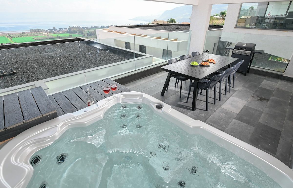 Une terrasse sur le toit équipée d’un jacuzzi, d’une table à manger, de chaises et d’un barbecue.