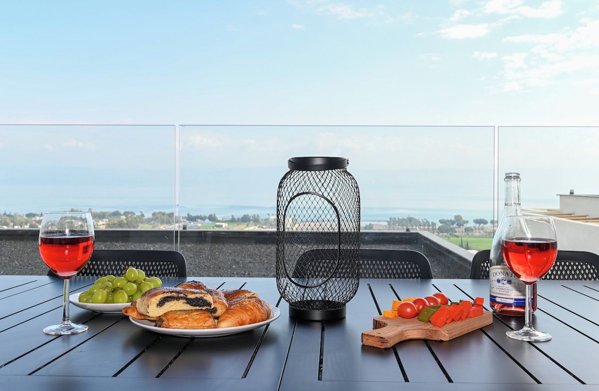 Une table dressée avec de la nourriture et des boissons sur un balcon donnant sur un paysage magnifique.