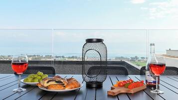 Une table dressée avec de la nourriture et des boissons sur un balcon donnant sur un paysage magnifique.