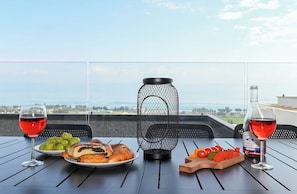 Une table dressée avec de la nourriture et des boissons sur un balcon donnant sur un paysage magnifique.