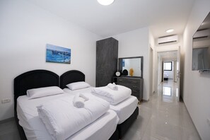 Ein Hotelzimmer mit zwei Betten, einem großen Spiegel, einem Gemälde an der Wand und einem modernen Design.