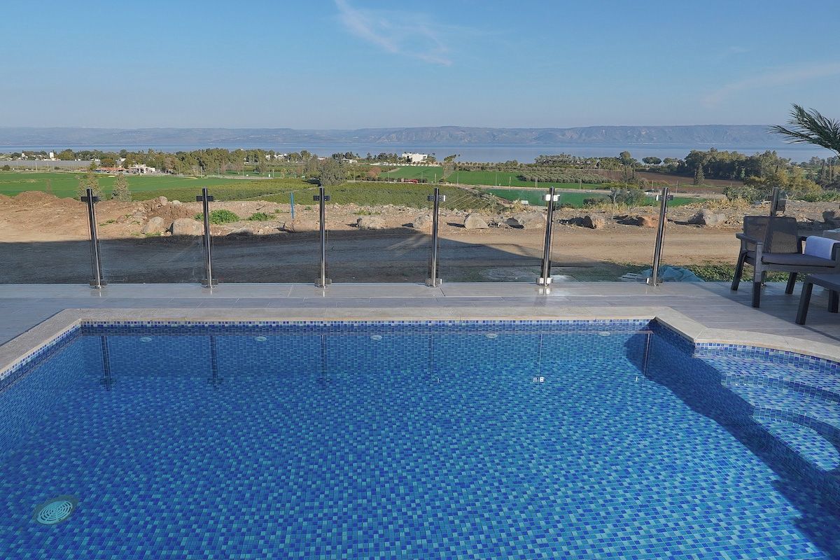 Une piscine avec vue sur un terrain de golf et sur des montagnes lointaines.