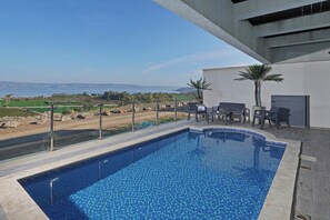 Une piscine avec vue sur le paysage, un espace extérieur aménagé pour se détendre et un style architectural moderne.