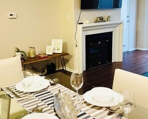A dining area with a striped tablecloth, white plates, and wine glasses set for a meal. - Amazing Apt/nice pool/gym/free parking (Culver City)