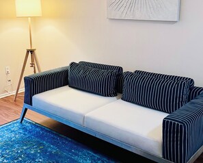 A modern living room with a sofa, a floor lamp, and a blue rug. - Amazing Apt/nice pool/gym/free parking (Culver City)