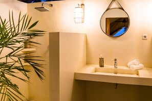 A bathroom with a sink, mirror, towel, and showerhead. - Autentik Penida (Klungkung)