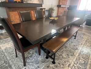 Un comedor con una mesa larga, sillas y bancos.