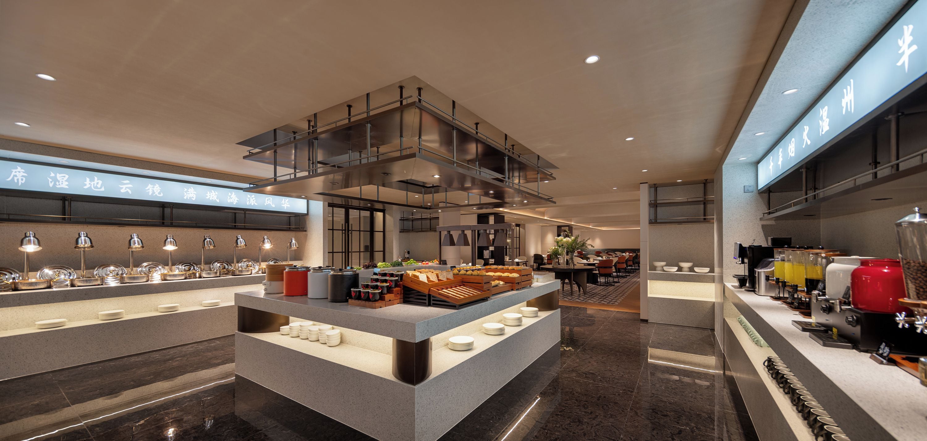 A modern hotel lobby with a central island, seating area, and a reception desk.