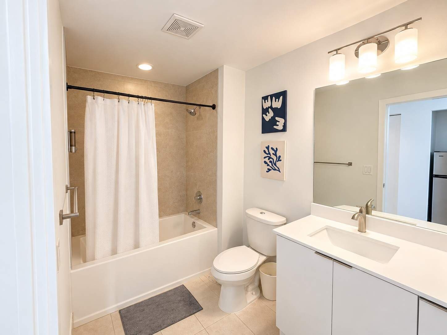 A modern bathroom with a bathtub, toilet, and sink.