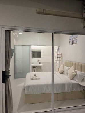 A room with a bed, a bathroom, and a sliding door. - Treat Boutique Huahin 94 (Hua Hin)