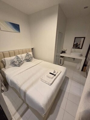 A hotel room with a bed, a bedside table, a mirror, and a bathroom area. - Treat Boutique Huahin 94 (Hua Hin)