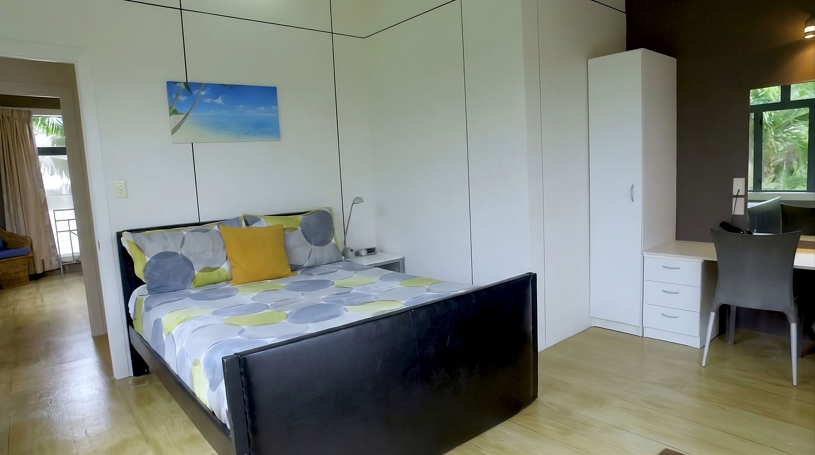 Un dormitorio moderno con cama, escritorio y armario.