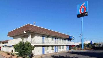 Un motel con techo plano, varias ventanas y un letrero llamativo con el número 6.
