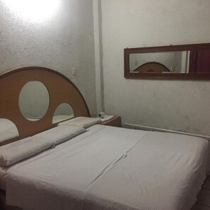 A single bed with a wooden headboard and a mirror above it. - Hotel Paraiso Express (Veracruz)