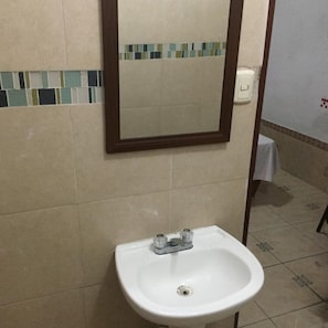 A bathroom with a white sink, a mirror, and a tiled backsplash. - Hotel Paraiso Express (Veracruz)