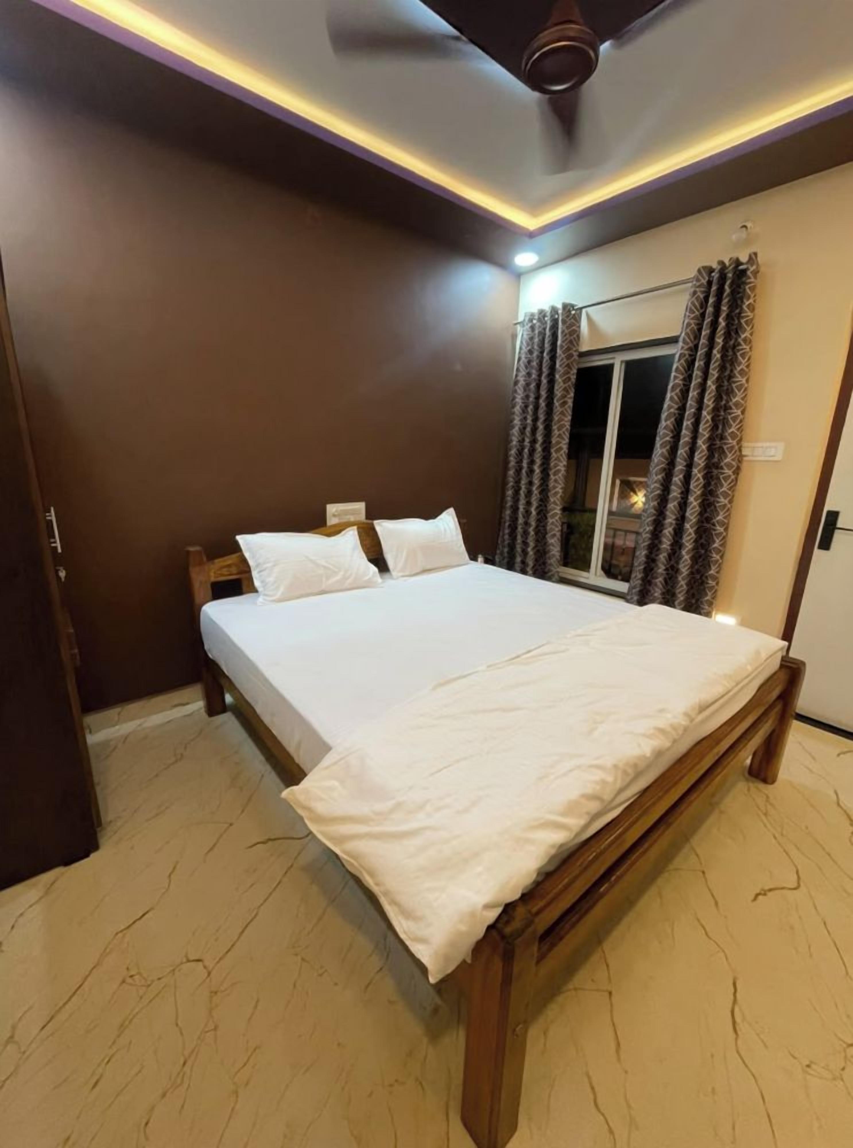 A neatly made bed with white linens in a room with a wooden headboard.