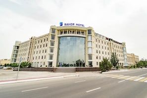 En stor byggnad med flera våningar, en framträdande glasfasad och en skylt högst upp med texten ”BAHOR HOTEL”.