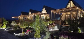 Un resort con diverse strutture coperte, un giardino curato e una zona piscina.