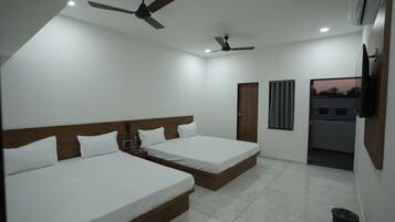 A hotel room with two beds, a ceiling fan, an air conditioning unit, and a view of the outside.